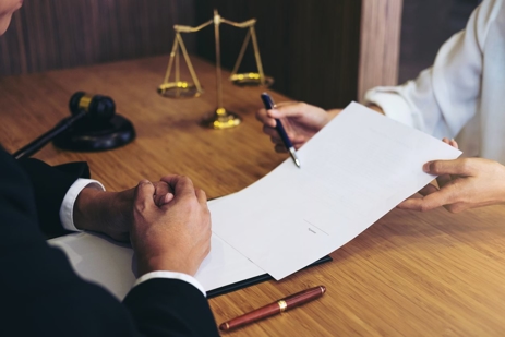 a close-up of a man signing a contract
