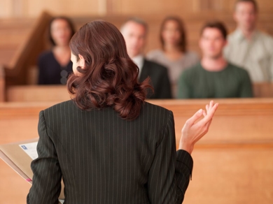 a woman in a suit speaking to a group of people
