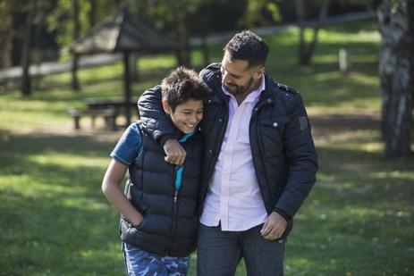 a man and boy standing together
