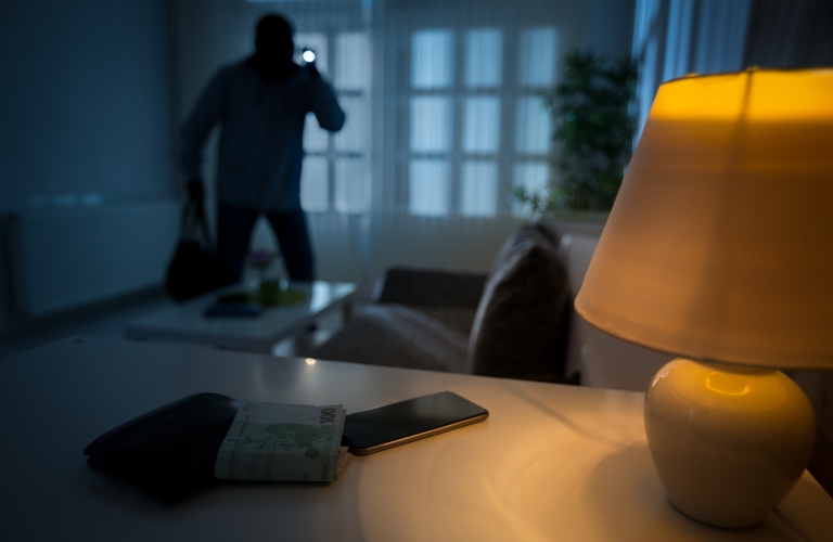 masked burglar enters house with flashlight