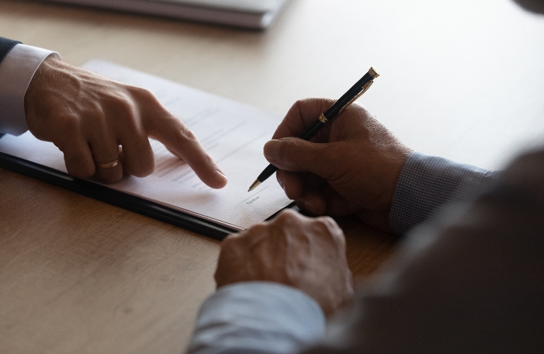 Hands of lawyer pointing where to sign